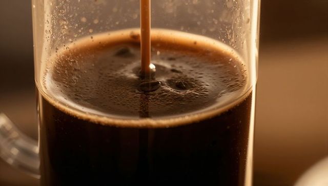 Brewed Dark Coffee Pouring into French Press Glass