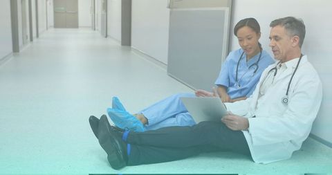 Medical Professionals Discussing Patient File in Hospital Corridor