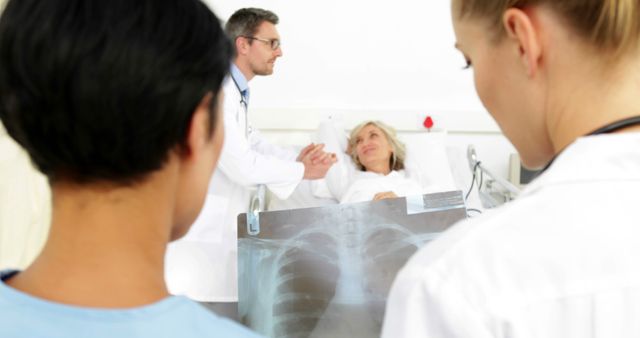 Doctors Analyzing X-Ray While Comforting Hospitalized Elderly Patient - Download Free Stock Images Pikwizard.com