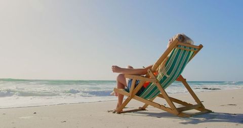 Relaxed Woman Enjoying Sun on Beach Lounge Chair