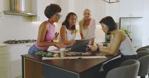 Diverse women collaborating in kitchen for wedding planning