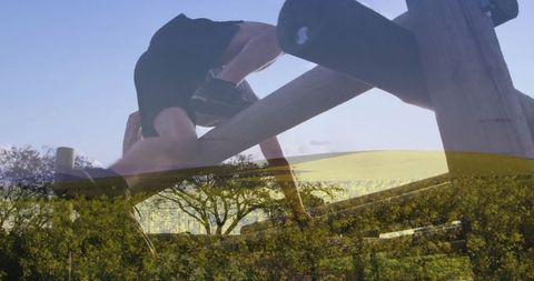 Shirtless climber on wooden obstacle in blooming wildflower field