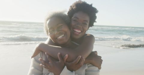 Joyful Mother and Daughter Embracing at Beach
