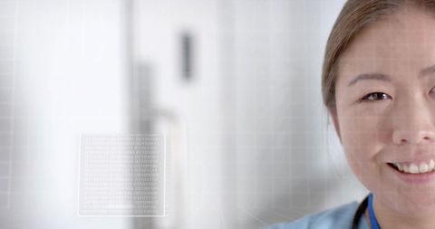 Smiling Korean Nurse in Scrubs with Digital Code Overlay in Modern Clinic