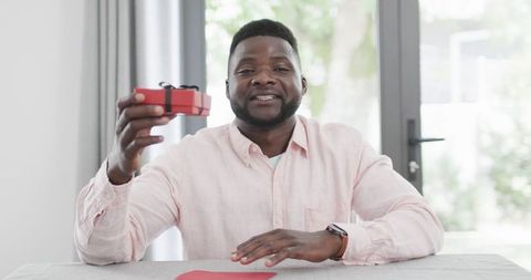 African American Man Presenting Gift on Video Call at Home
