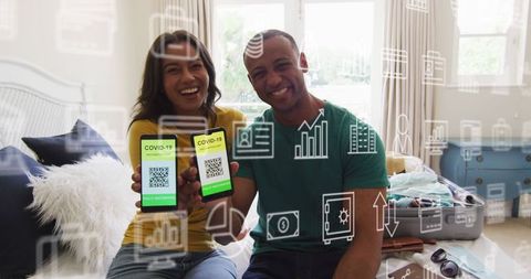 Happy couple displaying covid-19 vaccination certificates on smartphones