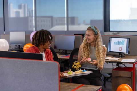Coworkers celebrating birthday at office cubicles with decorations