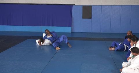 Martial Arts Instructor Demonstrating Ground Choke Hold Technique at Dojo