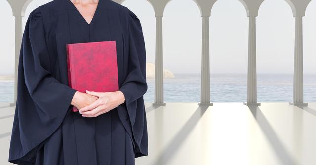Midsection of judge wearing traditional black robe, holding red book while standing in front of ocean view background with classical columns. Ideal for using in legal profession concepts, educational materials about the judiciary, promotions for law firms, or inspirational content focusing on justice and authority.