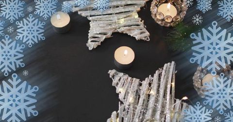 Glowing whitewashed twig stars sparkling with fairy lights and tealights on dark tabletop