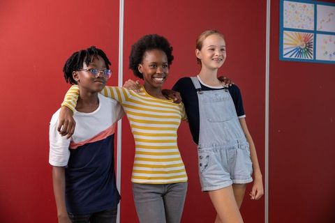 Diverse group of friends embracing in school environment