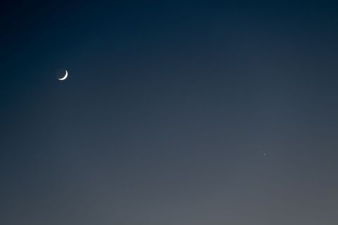 Crescent moon and distant stars in night sky