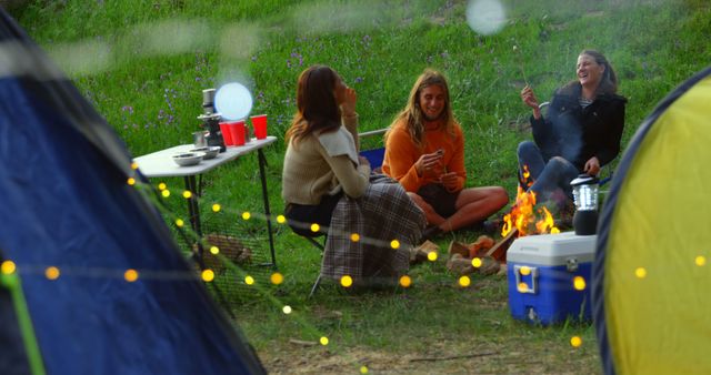 Friends Enjoying Campfire in Nature Surrounded by Tents and Fairy Lights - Download Free Stock Images Pikwizard.com