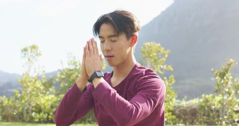 Man Meditating Outdoors in Nature Near Mountains