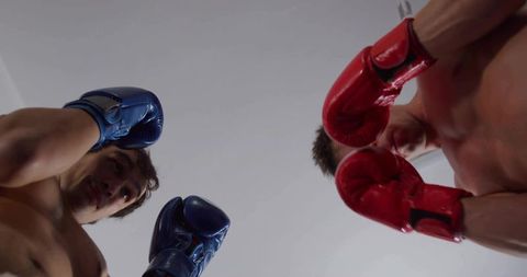 Dynamic Sparring Match with Shirtless Boxers Wearing Red and Blue Gloves