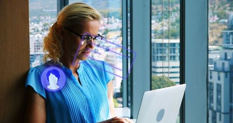 Professional businesswoman using laptop with holographic interface in office