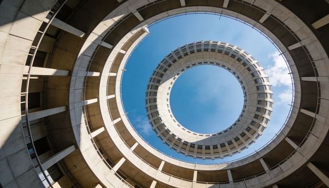 Concentric Concrete Spiral Ramp Framing Clear Blue Sky with Dramatic Sunlight