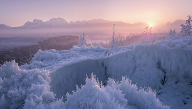 Sunrise over frosted canyon with ice crystals on ledge and misty mountain valley