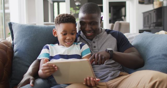 Father and Son Using Digital Tablet on Couch at Home - Download Free Stock Images Pikwizard.com