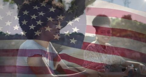 Women holding hands in car with american flag overlay conveying intimacy and patriotism