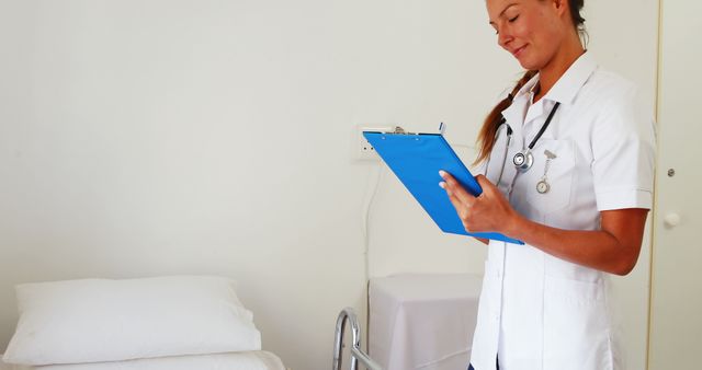 Smiling Nurse Writing on Clipboard in Hospital Room - Download Free Stock Images Pikwizard.com