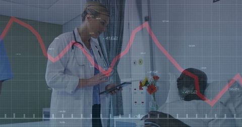 Doctor Reviewing Patient Information on Tablet in Hospital Room