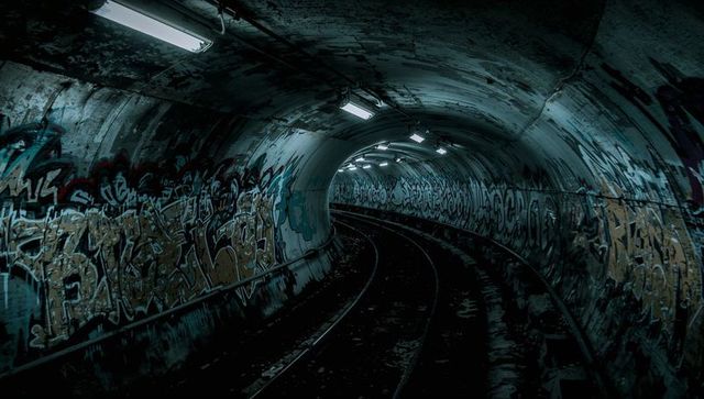 Gritty urban subway tunnel with graffiti and tracks