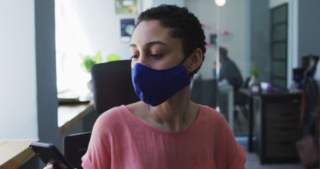 Young Woman Wearing Face Mask Checking Phone in Office - Download Free Stock Images Pikwizard.com