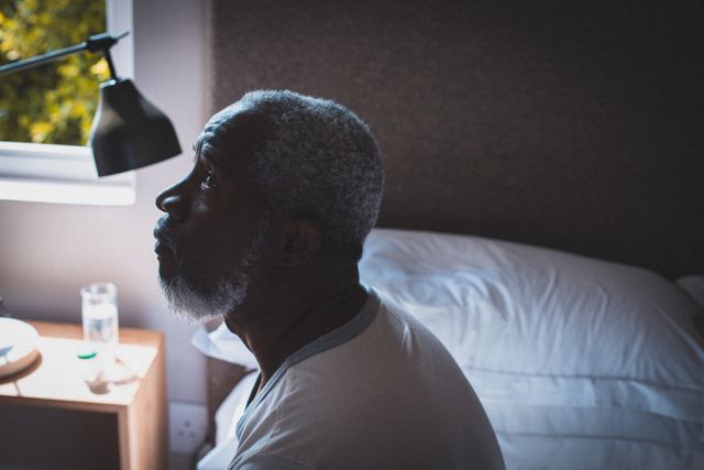 Senior African American Man Sitting on Bed in Thought - Download Free Stock Photos Pikwizard.com