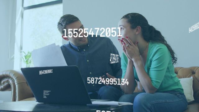 Caucasian couple is sitting on a couch, focusing on a laptop screen illuminated by streaming digital numbers. Ideal for content about financial planning, digital budgeting apps, financial stress management, or technology in everyday life.