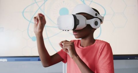 Boy Exploring Virtual Atomic Model with VR Headset in Laboratory