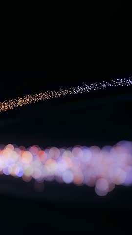 Vertical abstract light arcs shifting right vertical video with bokeh and fiber-optic glow