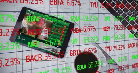 Tablet streaming live sports on desk with laptop and coffee, stock market tickers overlay