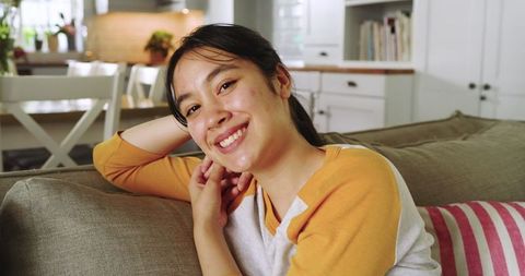 Cheerful Woman Relaxing on Sofa in Modern Living Room