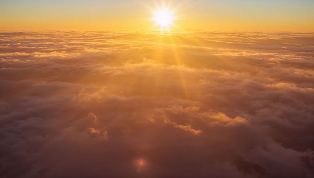 Radiant Sunrise Above Dramatic Cloudscape Casting Warm Golden Glow