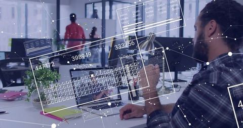 Bearded developer working on laptop with holographic data overlays in coworking office