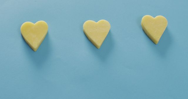 Three Yellow Heart-Shaped Butter Placed on Light Blue Background - Download Free Stock Images Pikwizard.com