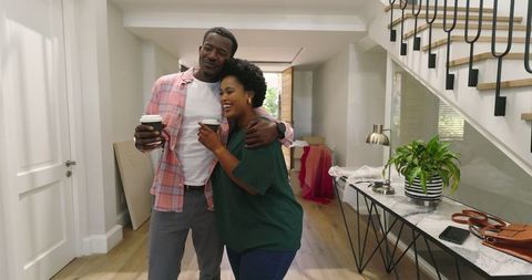 Couple Enjoying Morning Coffee Embrace in Contemporary Home