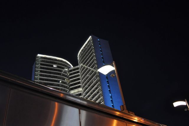 Photograph showcases a modern skyscraper with illuminated windows at night. Ideal for use in articles or websites related to urban development, real estate, modern architecture, or nightscape photography. Also suitable for marketing materials for city tours or corporate brochures.