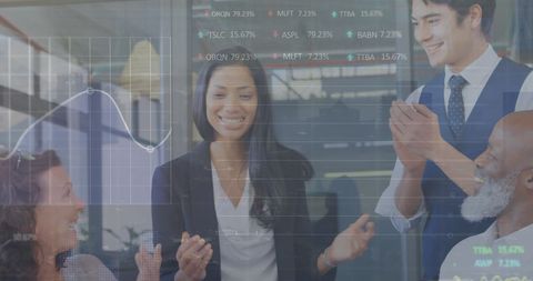 Diverse team celebrating in office with digital financial overlay