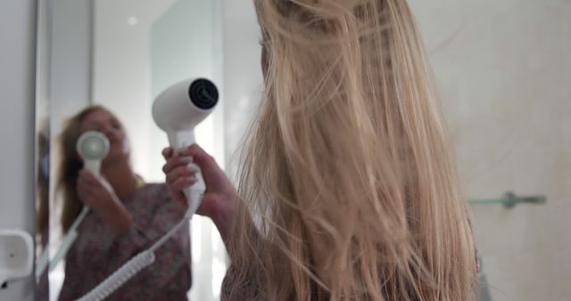 Woman Blow Drying Hair in Front of Bathroom Mirror - Download Free Stock Images Pikwizard.com