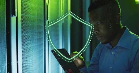 It technician securing data center using tablet with holographic cybersecurity shield
