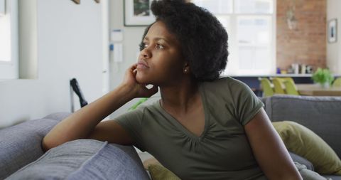 Thoughtful Woman Relaxing on Sofa at Home Looking Out Window - Download Free Stock Images Pikwizard.com