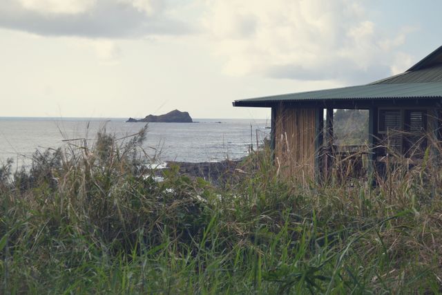 Rustic Coastal Cabin Overlooking Ocean with Distant Island - Download Free Stock Photos Pikwizard.com