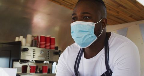 Food Truck Worker Wearing Face Mask Serving Drinks with Safety Measures