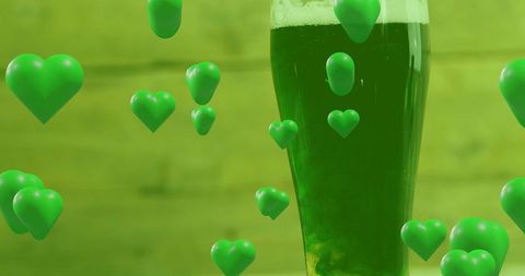 Green pilsner releasing heart-shaped bubbles and foam for st patrick celebration campaigns