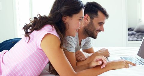 Couple Enjoying Laptop Time Together in Bedroom Setting