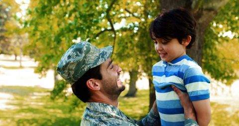 Soldier in Uniform Lifting Smiling Young Boy in Park - Download Free Stock Images Pikwizard.com