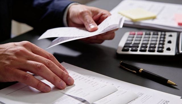 Accountant Sorting Receipts with Calculator and Pen Closeup of Bookkeeping Workflow