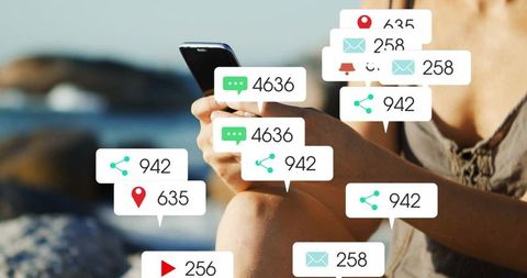 Woman holding smartphone on rocky shore with floating social notifications